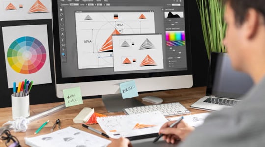 Diseñador gráfico trabajando en diseños en su computadora