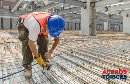 trabajador de la construccion amarrando alambres galvanizados Trabajador de la construcción amarrando malla electrosoldada con alambres galvanizados