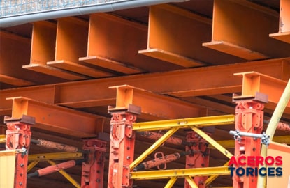 viguetas de acero de color naranja colocadas en una construccion Viguetas de acero anaranjadas colocadas dentro de una construcción