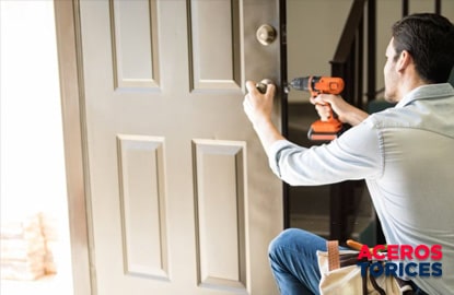 hombre instalando una cerradura en su puerta Hombre instalando una cerradura de tipo tubular en su puerta