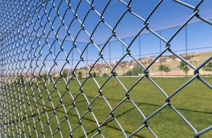 malla ciclonica como cerramiento de una cancha de futbol Malla ciclónica marcando el perímetro alrededor de una cancha de futbol
