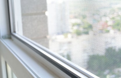 una ventana con con proteccion de malla mosquitera Close up a una ventana con protección de malla mosquitera