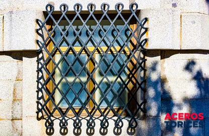 Ventana con protección de soleras dobladas en forma de moño