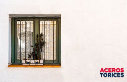 Una ventana con protección de herrería compuesta por barras de acero