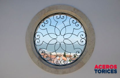 Ventana redonda con vista al mar con protección hecha de soleras