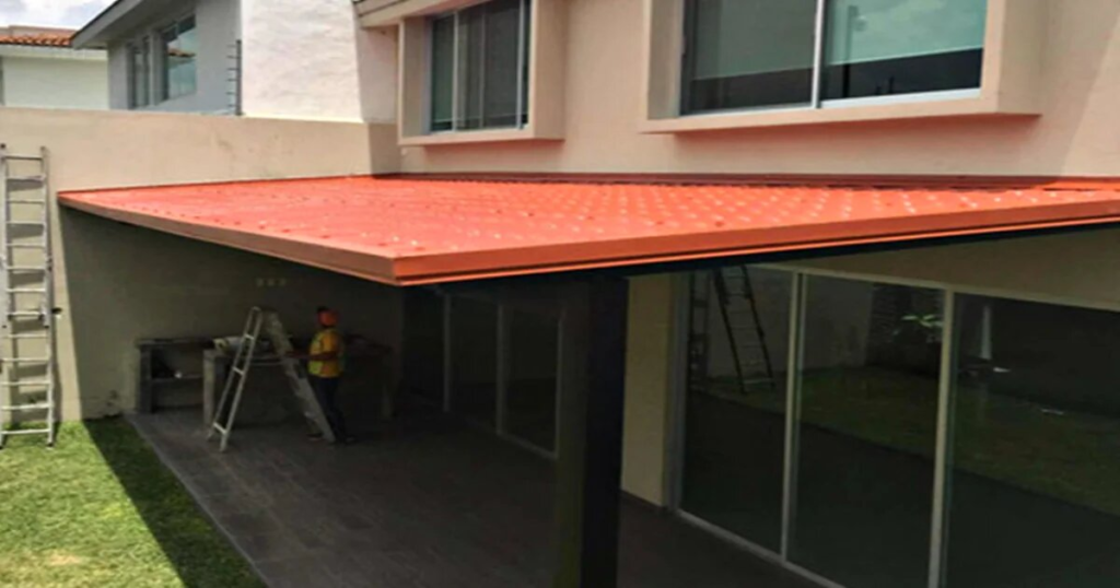 tejaban de pvc tricapa patio residencial0A Tejabán de lámina PVC tricapa instalado en patio con jardín