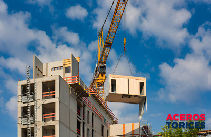 grua transportando un modulo de madera Grúa transportando un módulo de madera hacia la parte superior de un edificio