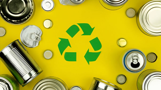Símbolo ecológico en medio de latas y tapas metálicas - Metales reciclables